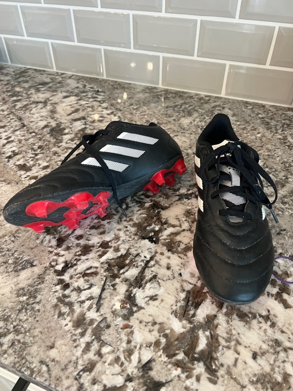 adidas Black Soccer Cleats with White Stripes and Red Studs